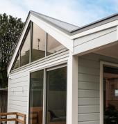 Modern Wellington home exterior featuring fresh weatherboard cladding, large sliding doors, and clean architectural detailing.