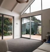 Bright renovated living space with high ceilings, full-height glazing, and seamless indoor outdoor flow.