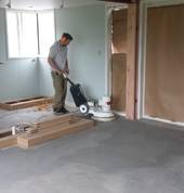 Progress sanding sub floor prior to installation of vinyl planks