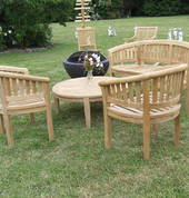 Outdoor peanut bench and chair setting and spare chairs being inspected by small concrete cricketers